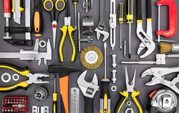 set of hand various work tools on grey background top view including different kinds of wrenches, pliers, clamps, calipers and other