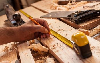 carpenter taking measurement of a wooden plank